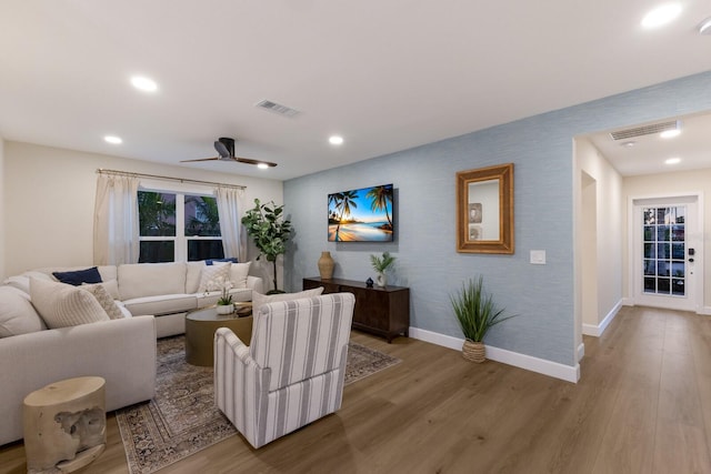 living room featuring ceiling fan and light hardwood / wood-style floors