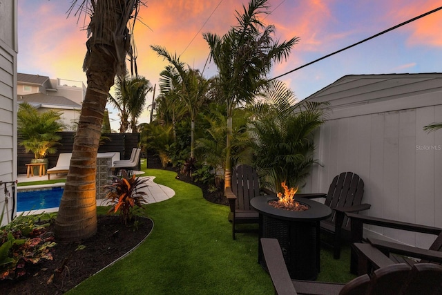 yard at dusk featuring a patio area, an outdoor bar, and a fire pit