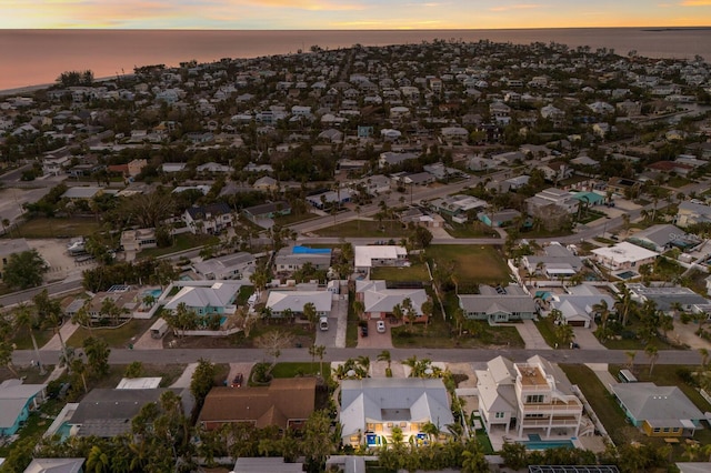 aerial view at dusk featuring a water view