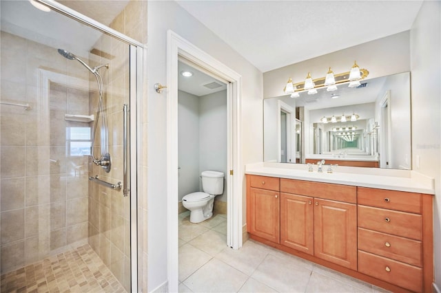 bathroom with tile patterned floors, vanity, toilet, and a shower with shower door