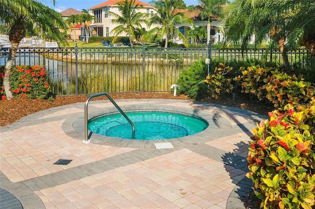 view of pool with a water view and a hot tub