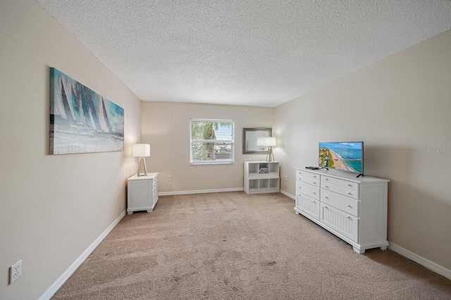 unfurnished room featuring a textured ceiling and light carpet