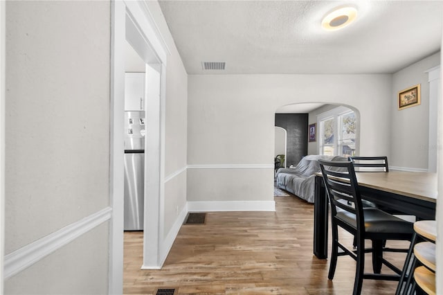 dining room with hardwood / wood-style flooring and a textured ceiling