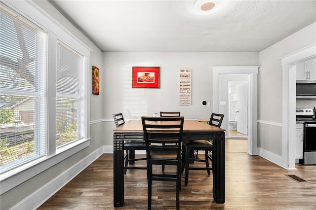 dining space with dark hardwood / wood-style flooring