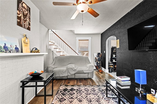 living room with hardwood / wood-style floors, ceiling fan, and a textured ceiling