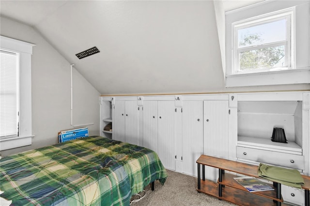 bedroom with light colored carpet and lofted ceiling