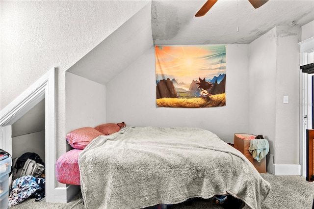 bedroom with carpet, a textured ceiling, vaulted ceiling, and ceiling fan