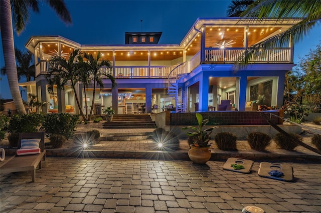 back house at night featuring a balcony