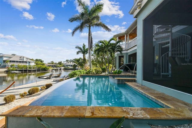 view of pool with a dock and a water view