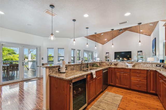 kitchen with high vaulted ceiling, light wood-type flooring, a textured ceiling, and beverage cooler