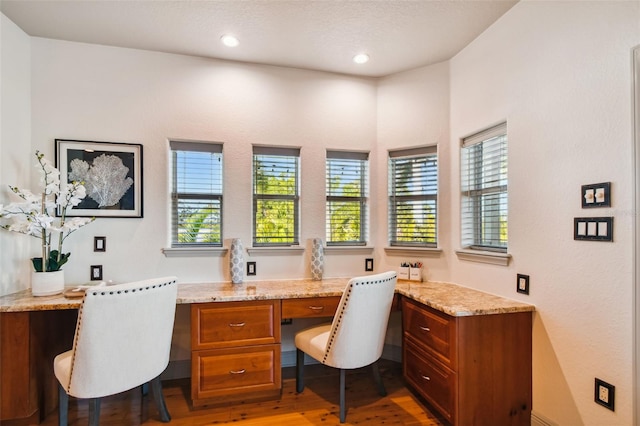 home office featuring hardwood / wood-style floors and built in desk