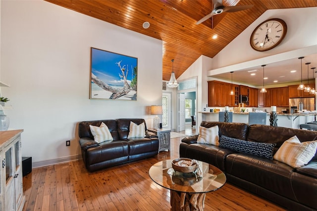 living room with ceiling fan with notable chandelier, hardwood / wood-style flooring, high vaulted ceiling, and wood ceiling