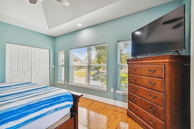 bedroom with ceiling fan, a closet, and light hardwood / wood-style floors