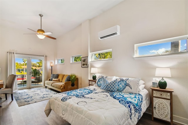 bedroom with access to outside, a wall mounted AC, ceiling fan, wood-type flooring, and high vaulted ceiling