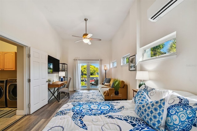 living room with dark hardwood / wood-style flooring, a towering ceiling, ceiling fan, separate washer and dryer, and an AC wall unit