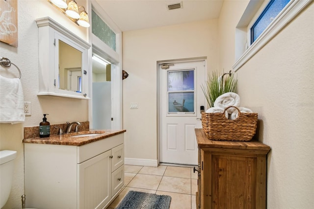 bathroom featuring tile patterned floors, vanity, and toilet