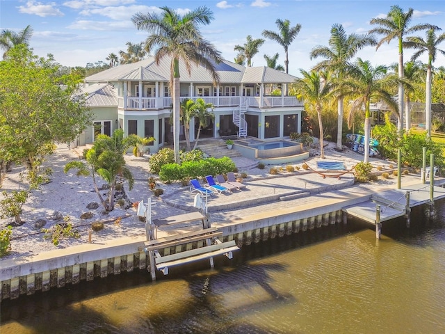 back of house with a water view, a patio area, and a balcony