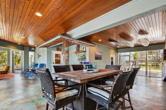 dining room with plenty of natural light, wooden ceiling, and concrete flooring