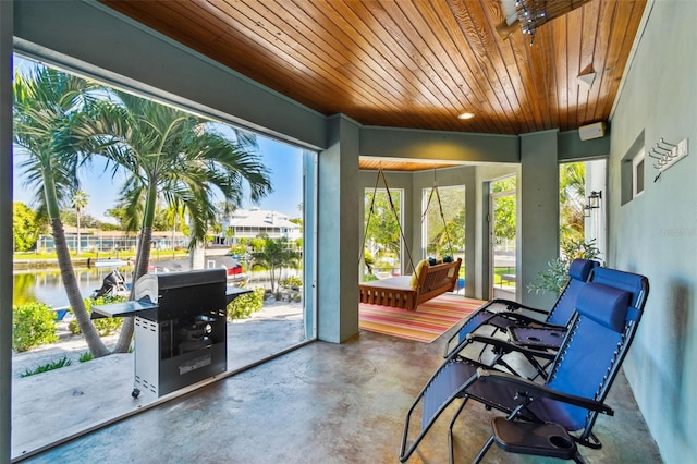 sunroom with a water view and wood ceiling