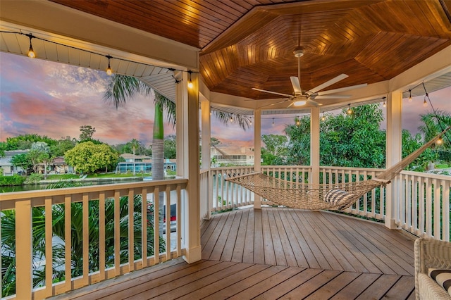 deck at dusk featuring ceiling fan