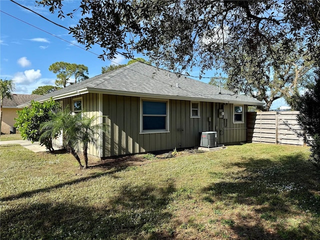 rear view of house with a yard and central AC unit