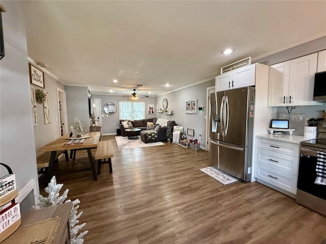 kitchen with electric range oven, ceiling fan, dark wood-type flooring, stainless steel fridge with ice dispenser, and white cabinetry