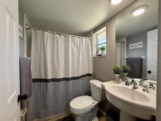 bathroom with sink, a shower with shower curtain, a textured ceiling, and toilet