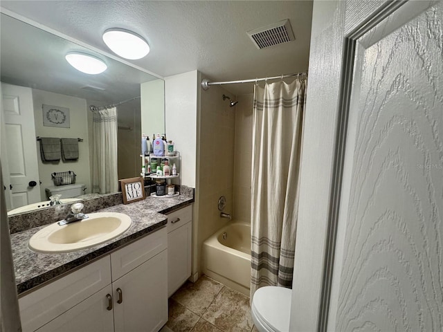 full bathroom featuring shower / bath combo with shower curtain, vanity, a textured ceiling, and toilet