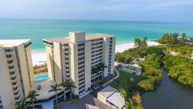 birds eye view of property with a water view and a beach view