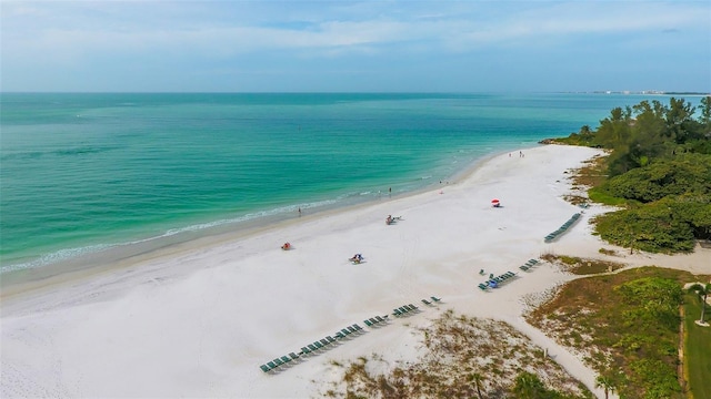 birds eye view of property with a water view and a beach view