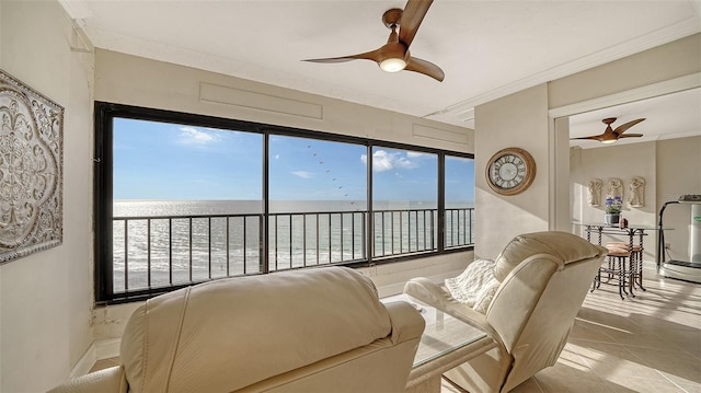 tiled living room featuring a water view, ceiling fan, and crown molding