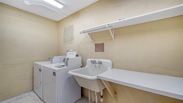 washroom with washer and dryer and sink