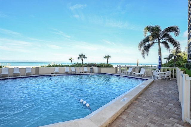 view of swimming pool with a water view and a patio