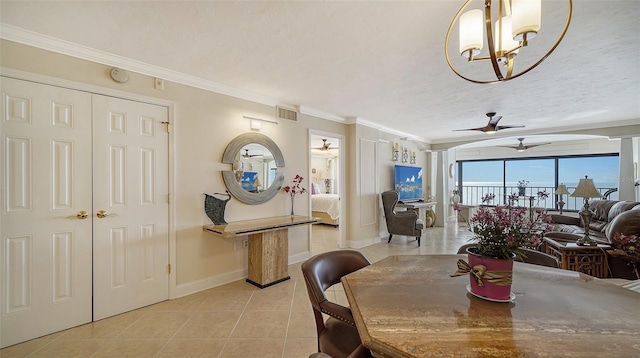 tiled dining area with crown molding, ceiling fan with notable chandelier, and a textured ceiling