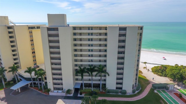 view of building exterior with a water view and a beach view