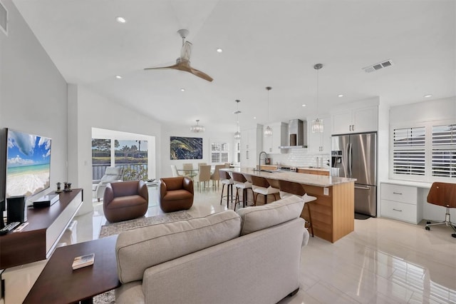 living room with ceiling fan, sink, and lofted ceiling