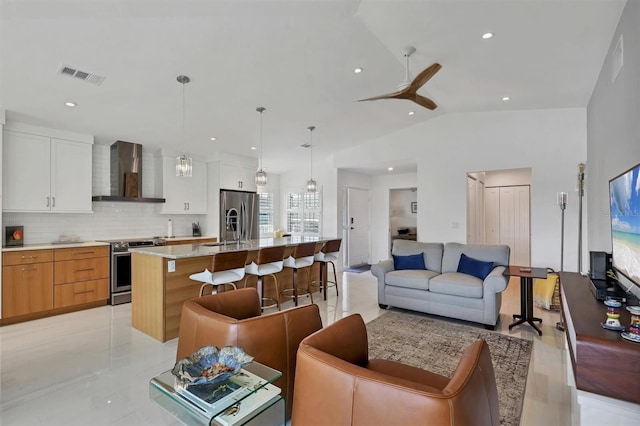 living room with ceiling fan, lofted ceiling, and sink