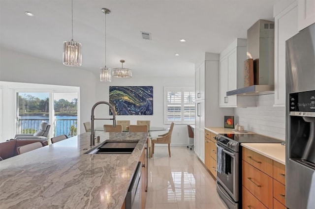 kitchen featuring white cabinets, a water view, sink, wall chimney exhaust hood, and light stone countertops