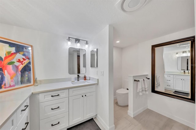 bathroom with tile patterned floors, vanity, toilet, and a textured ceiling