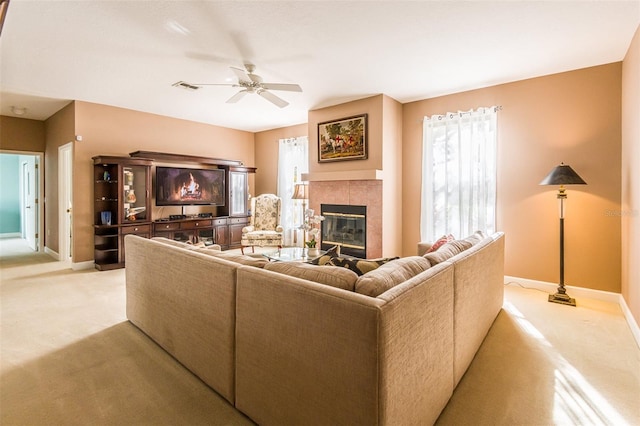 living room featuring light carpet, a fireplace, a wealth of natural light, and baseboards