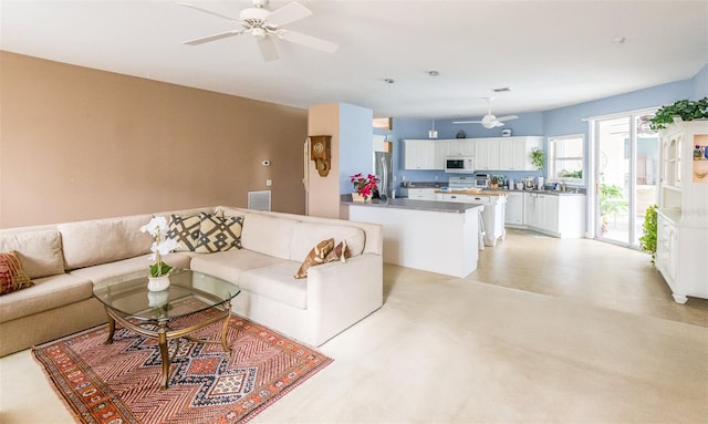 living area with visible vents and ceiling fan