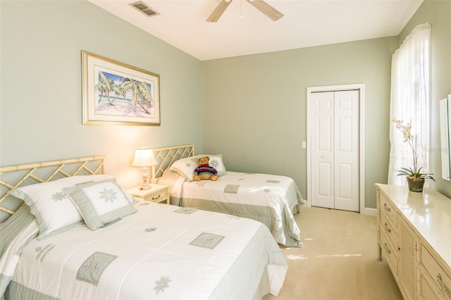 bedroom with a closet, visible vents, light carpet, ceiling fan, and baseboards