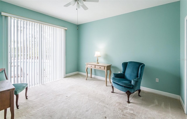 living area with a ceiling fan, baseboards, and carpet flooring