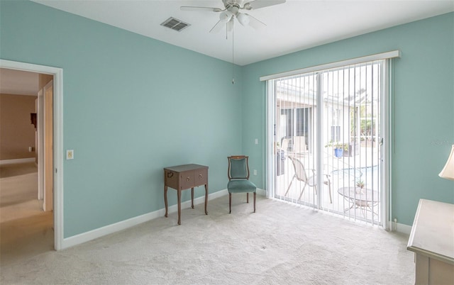 living area with ceiling fan, carpet floors, visible vents, and baseboards