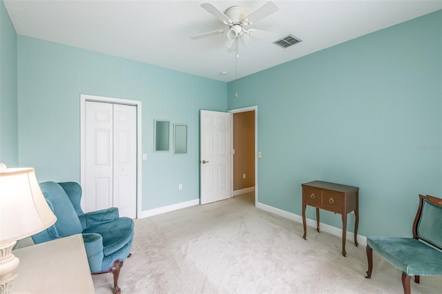 living area with baseboards, visible vents, ceiling fan, and carpet flooring