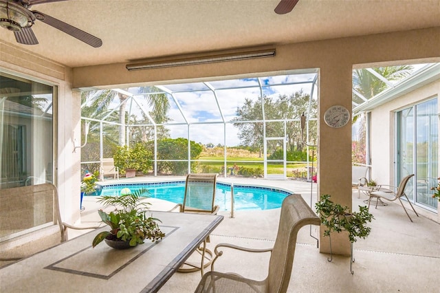 outdoor pool with a lanai, a patio area, and ceiling fan