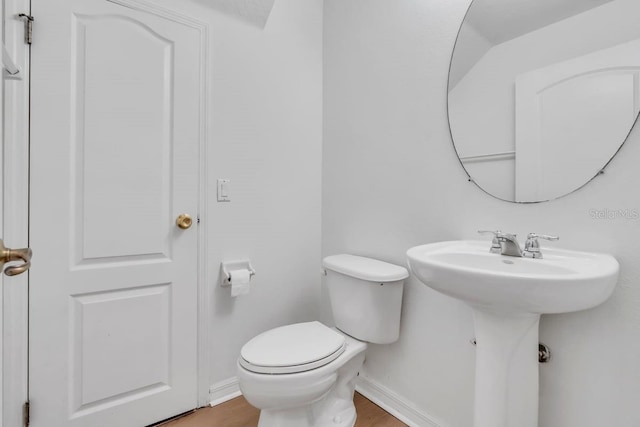 bathroom featuring wood-type flooring and toilet