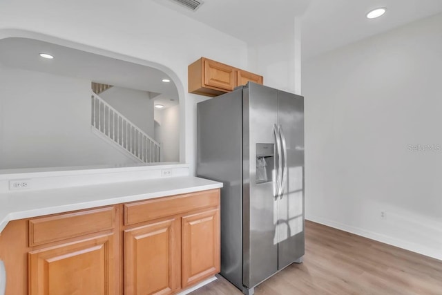 kitchen with light wood-type flooring and stainless steel fridge with ice dispenser