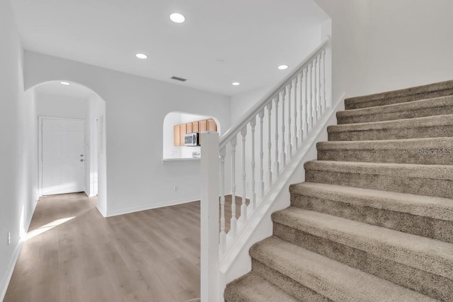 staircase with hardwood / wood-style floors