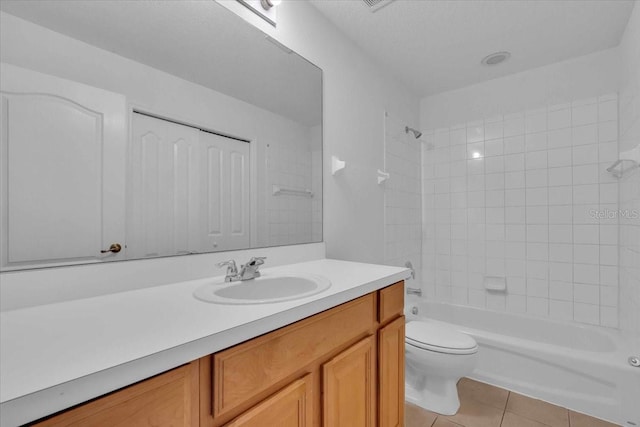 full bathroom with tile patterned flooring, vanity, tiled shower / bath combo, and toilet